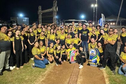 Furiosa Band de Nova Alvorada do Sul celebrando a vitória no Campeonato Sul-Mato-Grossense de Bandas e Fanfarras em Dourados, com troféus e baliza campeã.